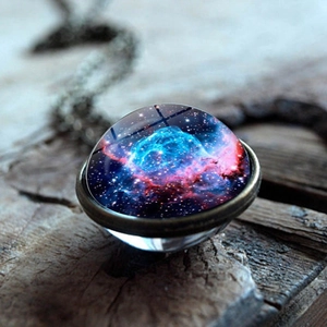 Macro detail of galaxy glass ball pendant with nebula pattern and bronze metal frame