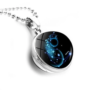 Close-up of glowing blue Aquarius constellation inside a glass ball pendant necklace