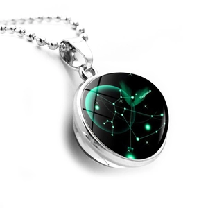 Macro shot of silver Sagittarius constellation glass ball pendant on beaded chain