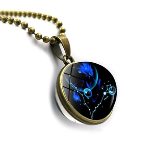 Detail of bronze Pisces zodiac pendant with blue double-sided glass orb and beaded chain