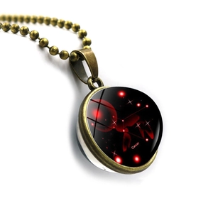 Macro shot of Cancer zodiac double-sided glass ball pendant with bronze bead chain
