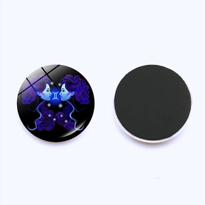Detail of a 25mm Gemini zodiac glass fridge magnet showing the front art and magnetic back