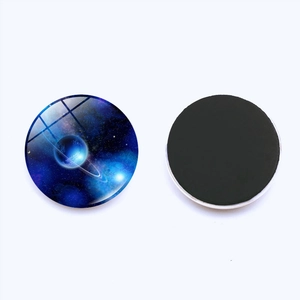Macro detail of round 25mm glass fridge magnets with blue galaxy and nebula design