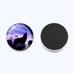 Detail of round howling wolf glass fridge magnets with magnetic back and starry sky pattern
