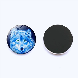 Close-up of circular glass fridge magnets featuring artistic blue wolf head illustrations