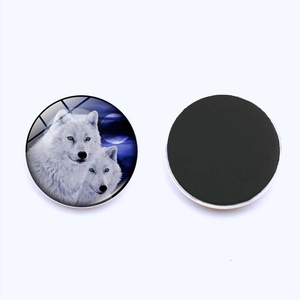 Detail of a 25mm round glass fridge magnet featuring two howling wolves under a full moon