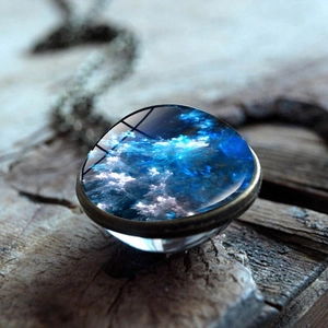 Macro view of a double-sided nebula glass ball pendant on a vintage bronze base
