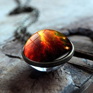 Macro shot of cosmic nebula pendant with double-sided glass dome on vintage wood