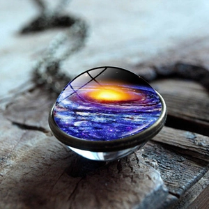 Macro detail of universe nebula glass ball pendant with cosmic purple and blue galaxy patterns