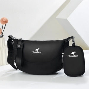 Minimalist black crescent crossbody bag with wide strap and matching mini coin purse
