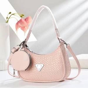 Detail of pink hobo bag with woven texture, metal triangle plaque and round charm