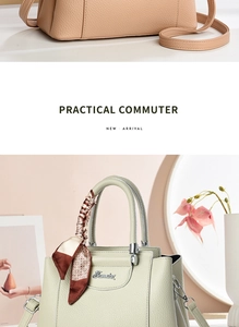 Detail of light green leather handbag featuring silk scarf handle and metal logo plaque