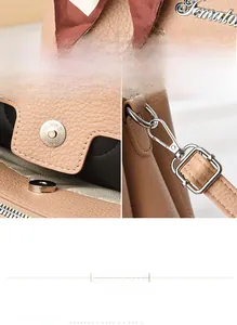 Detail of lychee pattern leather handbag with metal logo, scarf and magnetic clasp