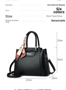 Close-up of black pebbled leather tote bag with printed silk scarf on handle and logo