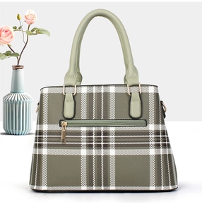 Detailed close-up of textured checkered handbag with gold zipper and green handle