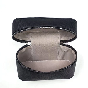 Detail of black pebbled leather handbag showing beige herringbone fabric lining inside