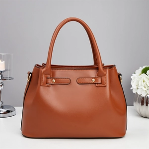 Close-up of brown crocodile texture leather handbag with metallic rivet details