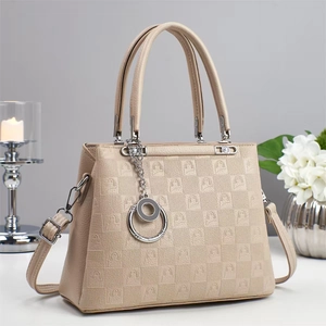 Detail of khaki tote bag with embossed logo pattern, silver hardware and top handles