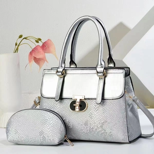 Close-up of silver tote bag set with snakeskin texture and gold metal buckle detail