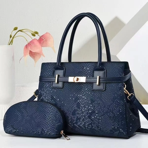 Close-up of deep blue snake-embossed leather tote bag with elegant gold metal clasp detail