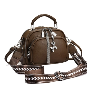 Brown litchi grain faux leather crossbody bag with wide strap and silver dog pendant