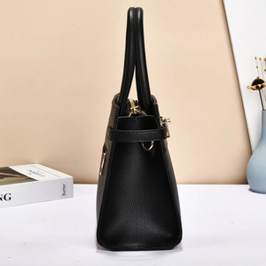 Vue latérale d'un sac à main noir en cuir grainé avec fermeture éclair dorée et détails