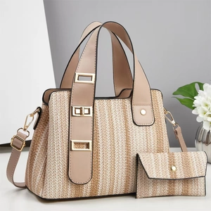 Detail of woven straw tote bag with cream stripes and elegant gold-tone hardware