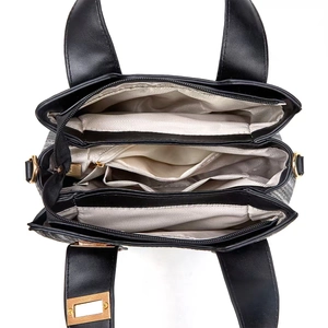 Interior view of large woven tote bag showing multiple compartments and gold hardware