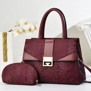 Burgundy snakeskin tote bag set with detachable strap and small pouch on white background