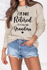 Close-up of heart and text print on beige long sleeve grandma sweatshirt