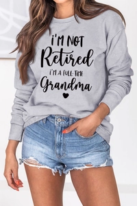 Detail of grey crewneck sweatshirt featuring I'M A FULL-TIME Grandma slogan and heart print