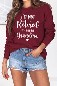 Detail of burgundy sweatshirt with white 'Full-Time Grandma' text and ribbed cuffs