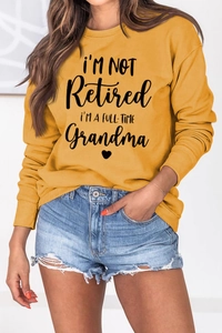 Detail showing high-quality letter print on ginger yellow long sleeve cotton sweatshirt