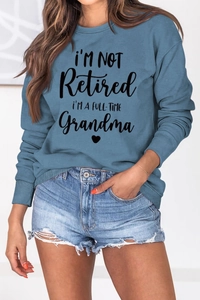 Detail of ribbed cuffs and full-time grandma print on blue crewneck sweatshirt