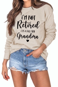 Detail of loose-fit beige sweatshirt with I'M A FULL-TIME Grandma print and ribbed cuffs