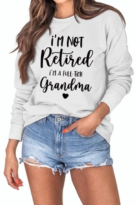 Close-up of I'm Not Retired I'm A Full-Time Grandma lettering on white crewneck sweatshirt