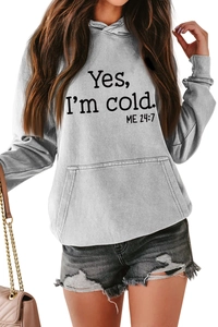 Detail of gray oversized hoodie featuring 'Yes, I'm cold' slogan and kangaroo pocket