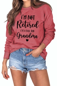 Detail of red crewneck sweatshirt with I'm Not Retired Full-Time Grandma print