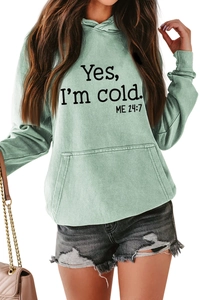 Detail view of mint green washed hoodie featuring Yes I'm Cold 24:7 artistic text