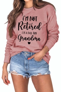 Detail of dusty pink sweatshirt with 'Full-Time Grandma' slogan and ribbed cuffs
