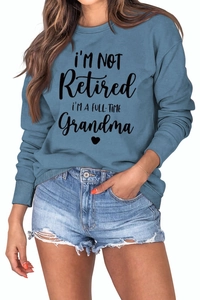 Close-up of blue long-sleeve sweatshirt featuring rib-knit crewneck and printed slogan