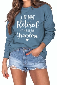 Close-up of I'm Not Retired I'm a Full-Time Grandma print on blue long sleeve sweatshirt