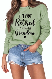 Detail of sage green sweatshirt with Grandma slogan and ribbed neckline texture