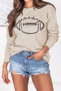 Détails de l'imprimé Game Day sur sweat beige et short en jean effiloché de près