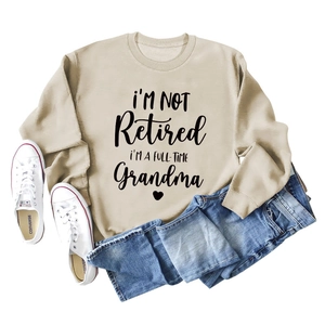Beige crewneck sweatshirt with Grandma text print paired with jeans and sneakers