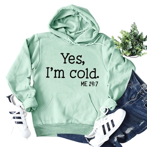 Close-up of Yes I'm cold ME 24:7 text on mint green hoodie with kangaroo pocket