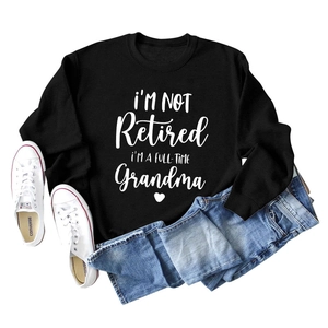 Black round neck sweatshirt with I'm Not Retired quote and blue jeans flat lay
