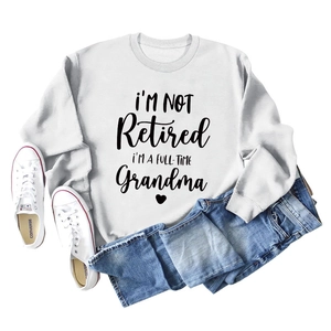 Detail of white long sleeve sweatshirt featuring a black slogan print and heart graphic