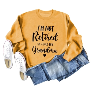Flat lay of mustard yellow sweatshirt with black lettering and blue jeans set