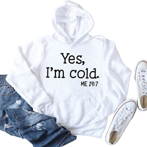 Flat lay of white hoodie with 'Yes I'm cold ME 24:7' print, drawstring and pocket